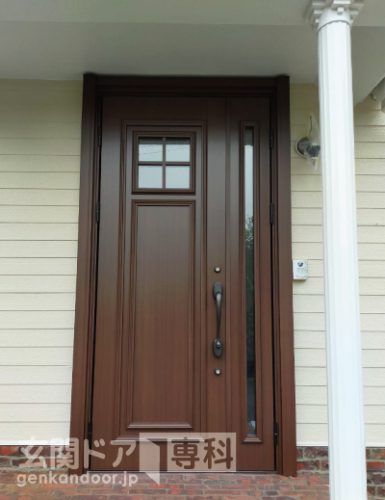青梅市長淵の玄関ドアリホーム工事　施工後の木目風な色合いの小窓付玄関ドア